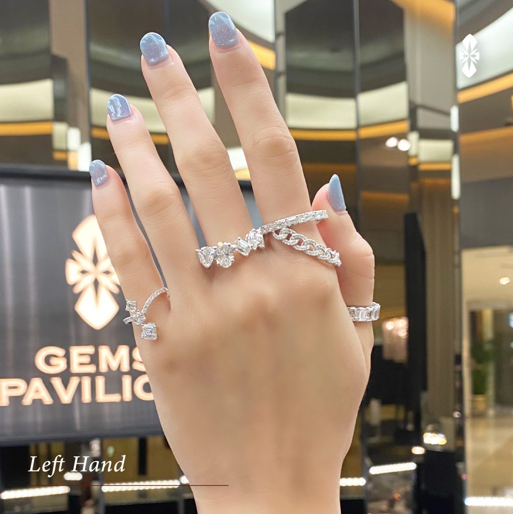 Beautiful girl with blue nails polish manicure and diamonds engagement  wedding ring on finger. Female holding hand on hair and bare shoulders.  Beauty and fashion concept. Close up, selective focus Stock Photo |